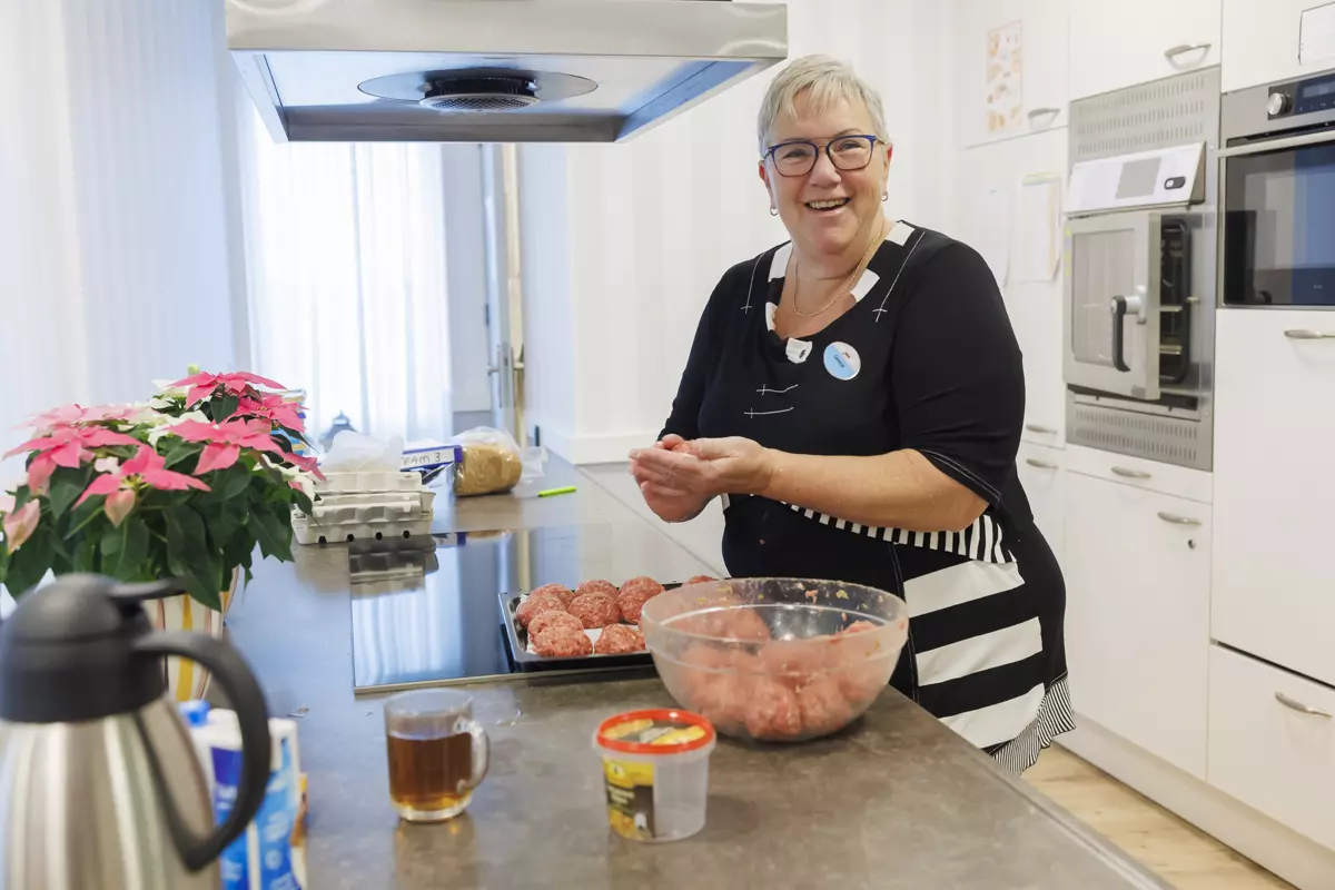 Woonassistent van KleinGeluk draait gehaktballen  voor de warme maaltijd
