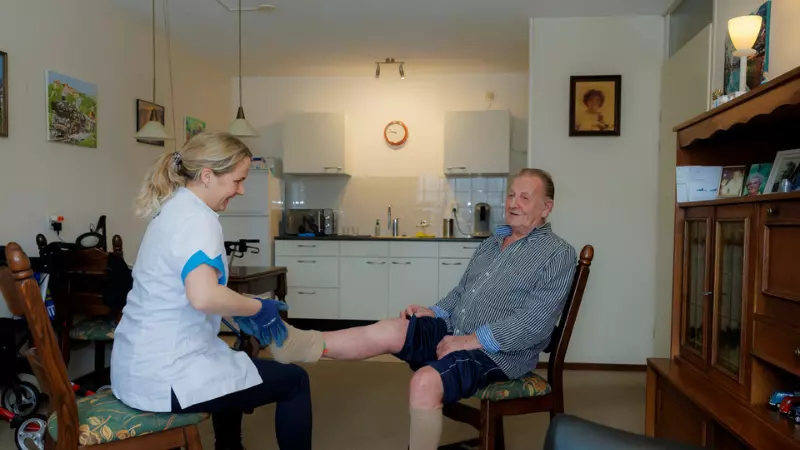 Medewerker van KleinGeluk helpt een bewoners met thuiszorg