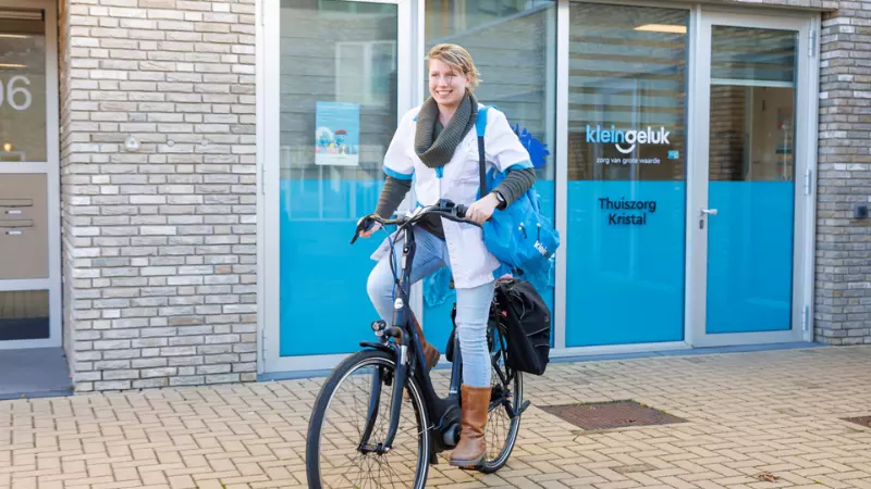 Medewerker van KleinGeluk stapt op de fiets naar werk
