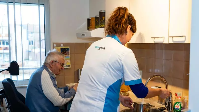 Medewerker van KleinGeluk is samen met een bewoner eten aan het klaarmaken