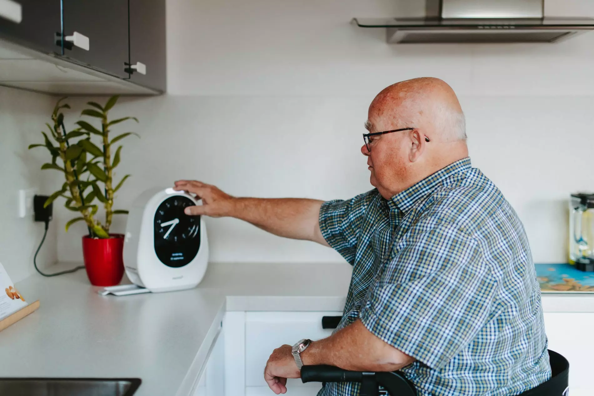 Meneer gebruikt de medicijn dispenser Medido in zijn thuiszorgwoning van KleinGeluk